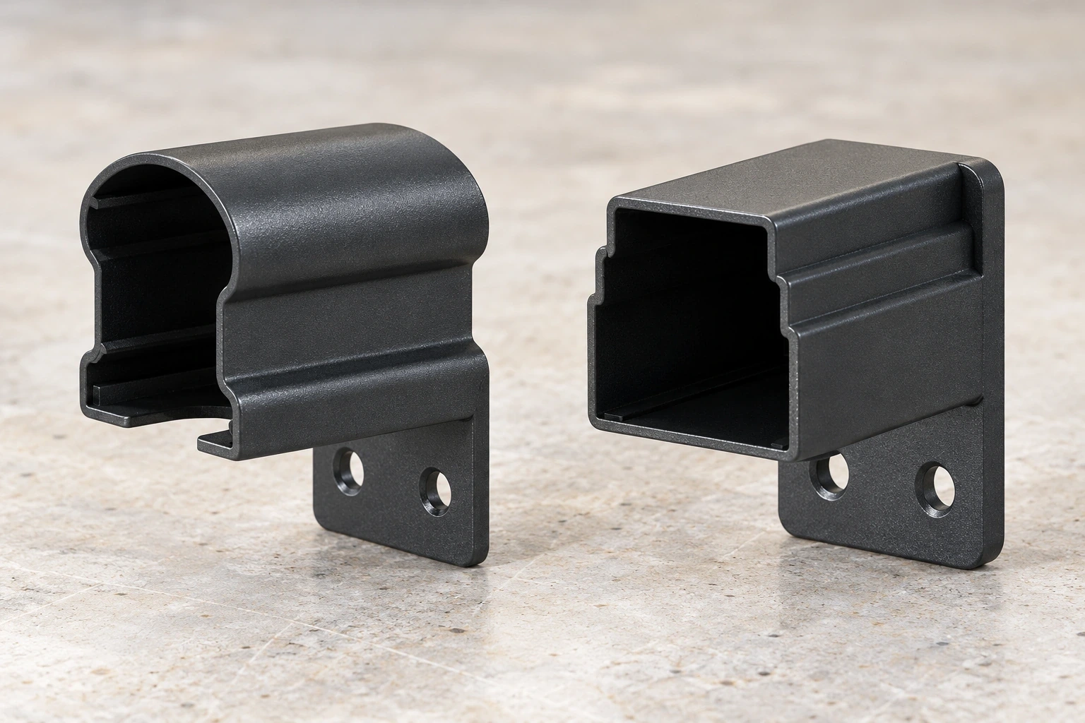 Rounded top-rail and rectangular bottom-rail brackets resting on a pale work surface.